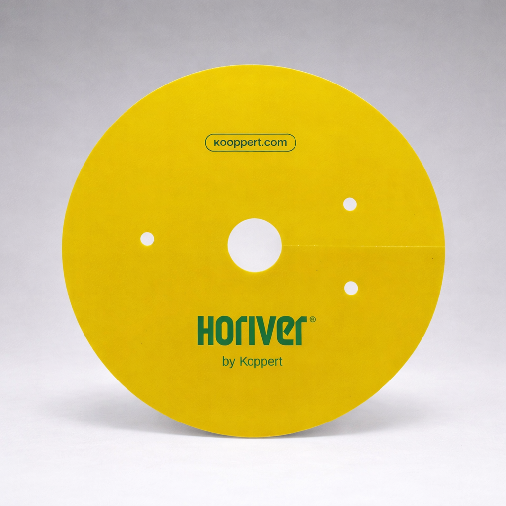 A round, yellow Horiver Professional Sticky Trap by Koppert with three small holes and a central hole stands upright against a plain gray background. "koppert.com" is printed at the top. Designed for pesticide-free Integrated Pest Management.